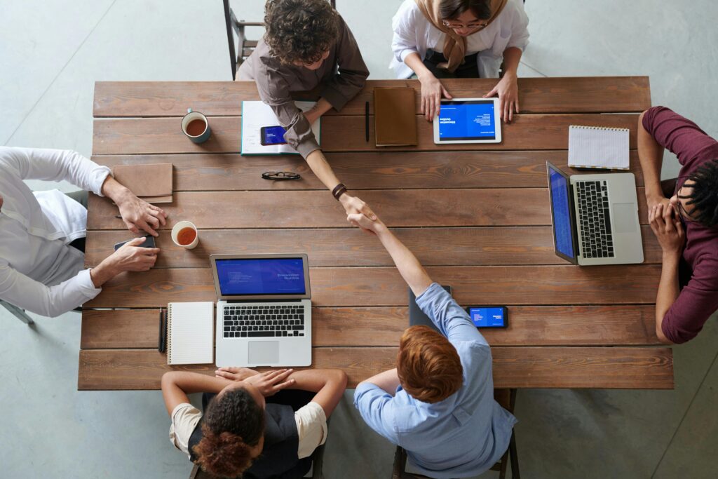 pexels photo 3184306 3184306 Overhead view of colleagues in a work meeting using laptops and tablets, emphasizing teamwork and technology.
